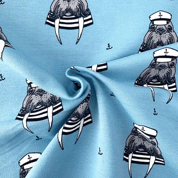 Tela de sudadera de algodón orgnaícos ocn morsas marienras sobre fondo azul claro